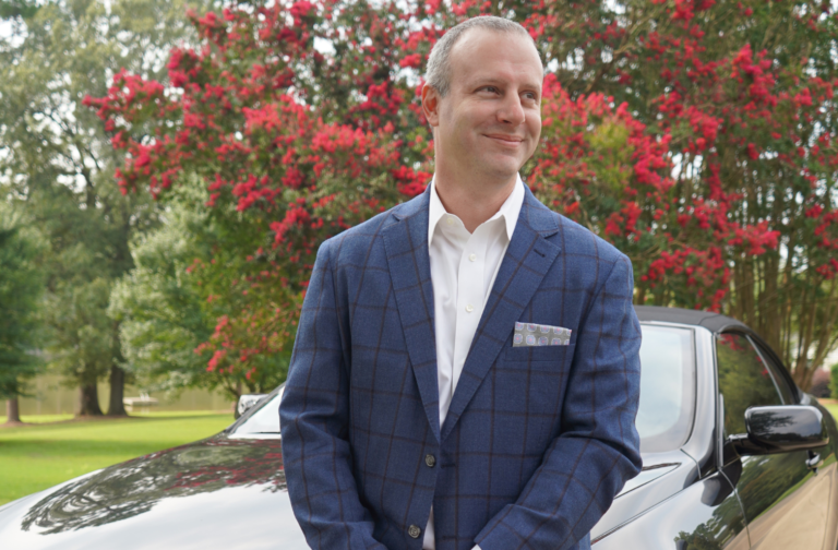 Michael Byars standing in front of his car reflecting on the mistakes he had to overcome when he was a new acquisition CEOs trying to buy a business.